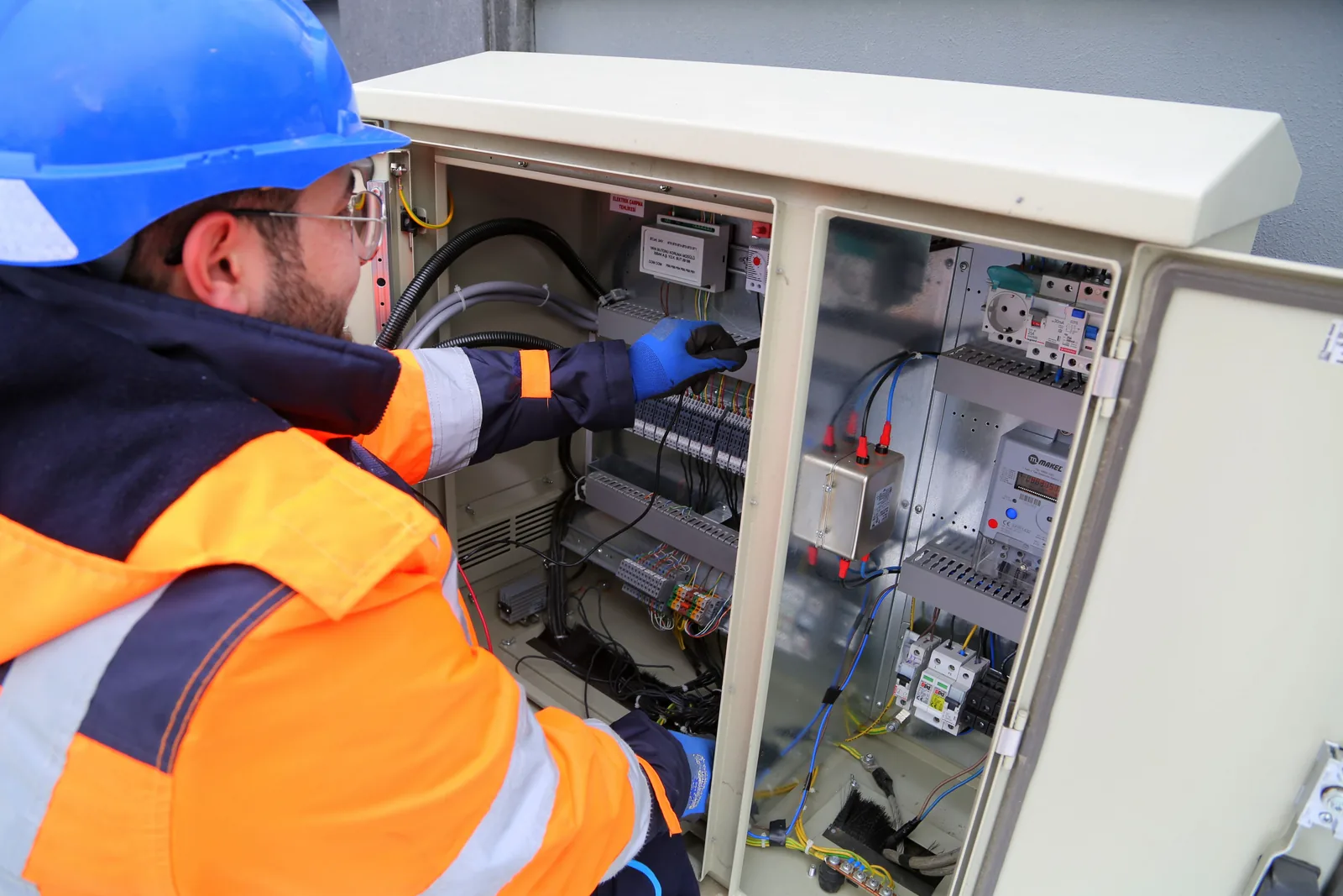An electrician working in an outdoor service cabinet, for outdoor lighting in Abbotsford